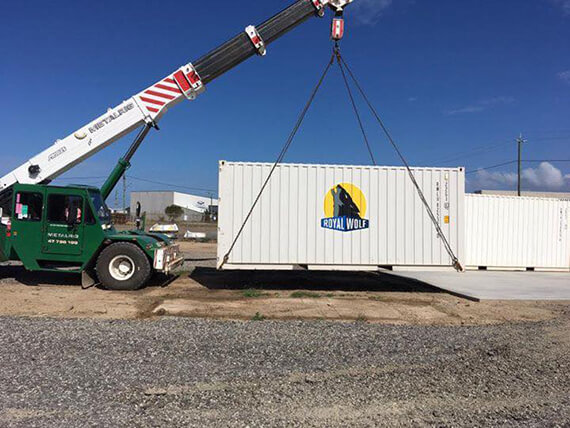 Green Truck Lifting a Container — Personalised & Secure Self Storage - Bonos' Bobcat & Tipper Hire